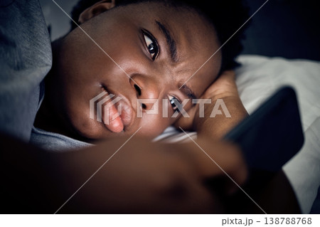 Insomnia, night and black woman in bed with phone for social media lying in room for addiction at home. Stress, lonely or sad person reading online to scroll on mobile app in bedroom with depression Insomnia, night and black woman in bed with phone for social media lying in room for addiction at home. Stress, lonely or sad person reading online to scroll on mobile app in bedroom with depression 138788768