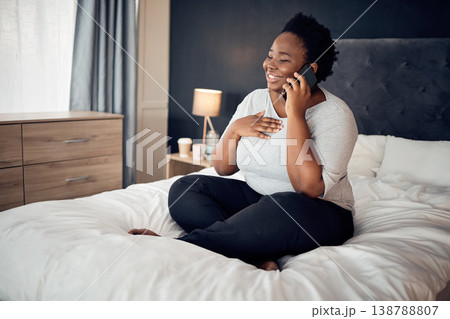 Phone call, happy and black woman on bed in home, talking and communication in the morning. Smartphone, conversation and African plus size person smile for discussion, chat and speaking in bedroom 138788807