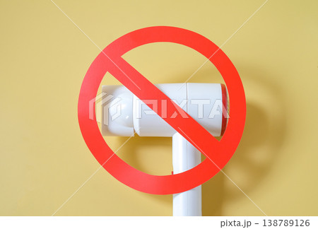 Hair dryer with prohibition sign on color background. Hair dryer with prohibition sign on color background. 138789126
