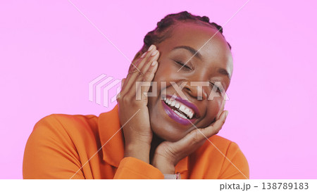 Woman, hands and happy on face with makeup, smile and excited with playful expression by pink background. Black person, emoji or self love for cosmetic, lipstick or beauty aesthetic and studio mockup 138789183