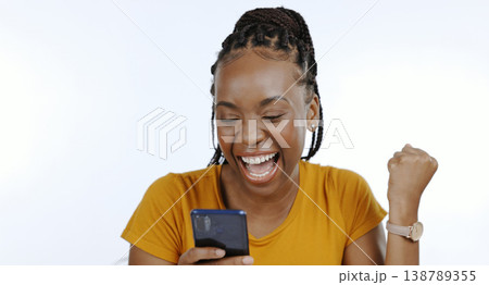 Phone, black woman and happy fist for success, celebration or achievement and winner for giveaway in studio on white background. Excited, prize and person with smartphone celebrate winning lottery Phone, black woman and happy fist for success, celebration or achievement and winner for giveaway in studio on white background. Excited, prize and person with smartphone celebrate winning lottery 138789355