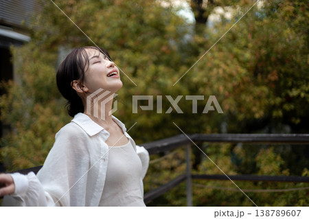 外の空気を吸ってリラックスしている若い女性 外の空気を吸ってリラックスしている若い女性 138789607