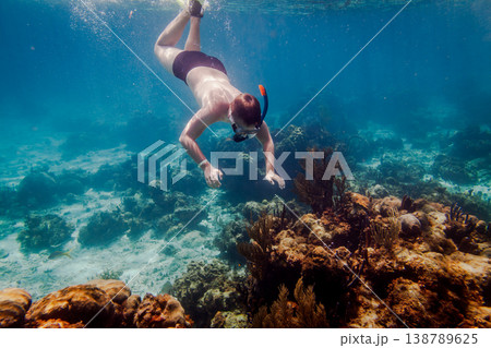 Man Snorkeling with Yellow Flippers in Coral Reef Turquoise Sea 138789625
