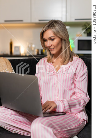 Adult woman freelancer starts evening workflow opens laptop types fast smiles checks tasks completed 138790213