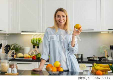 Young woman eating fresh apple in home kitchen enjoying healthy vitamins and nutrition fit lifestyle Young woman eating fresh apple in home kitchen enjoying healthy vitamins and nutrition fit lifestyle 138790715