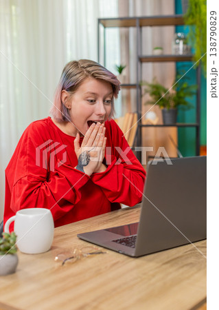 Woman opening laptop receiving lottery winning message, celebrating joyful excited happy reaction 138790829