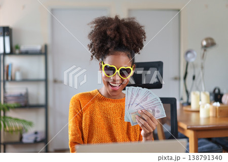 Young African American woman holding hundreds of dollar money banknotes. Young African American woman holding hundreds of dollar money banknotes. 138791340