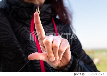 Woman making gesture with her hand outdoors Woman making gesture with her hand outdoors 138791474