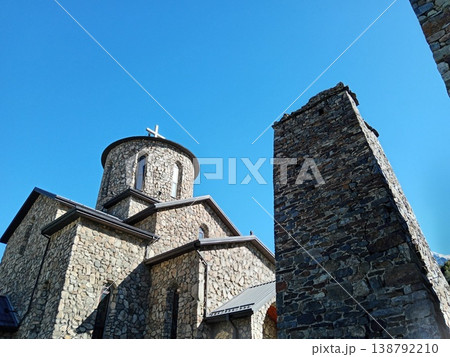 North Ossetia's stone Alan Monastery, Russia, bright summer weather. Ancient religious stone structure with mountain views and peaceful atmosphere North Ossetia's stone Alan Monastery, Russia, bright summer weather. Ancient religious stone structure with mountain views and peaceful atmosphere 138792210