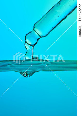 Pipette dripping blue liquid serum into clear water Pipette dripping blue liquid serum into clear water 138792272