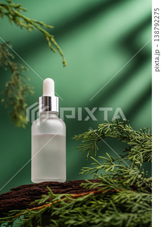 Glass cosmetic serum bottle on natural background with green leaves Glass cosmetic serum bottle on natural background with green leaves 138792275