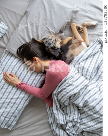 top view of sleeping woman and dog in bed. girl and pet sleep comfortably together and cuddle. top view of sleeping woman and dog in bed. girl and pet sleep comfortably together and cuddle. 138792380