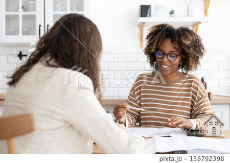 confident curly haired woman with curly dark hair, designer or realtor, shows mock up house.  138792398