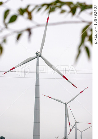 wind turbines in field rotate their blades to generate energy. windmill on spacious green field. wind turbines in field rotate their blades to generate energy. windmill on spacious green field. 138792407