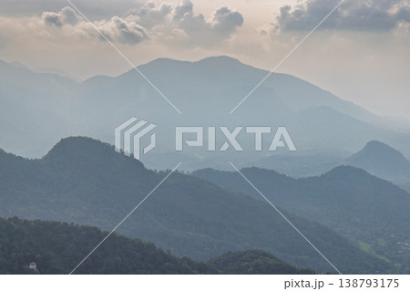 View from Ambuluwawa Tower, multi-religious temple complex located in Gampola, in Sri Lanka. Misty Mountain Layers with Hazy Atmosphere and Distant Peaks Under Cloudy Sky 138793175