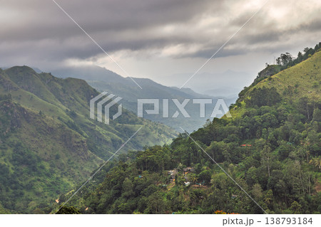 Dramatic Mountain Landscape with Lush Green Valleys and Overcast Sky, Showcasing Serene Natural Beauty and Remote Living. Mountain landscape near Ella in Sri Lanka. 138793184