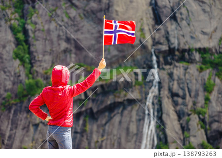 Tourist woman with norwegian flag in rocks mountains Tourist woman with norwegian flag in rocks mountains 138793263