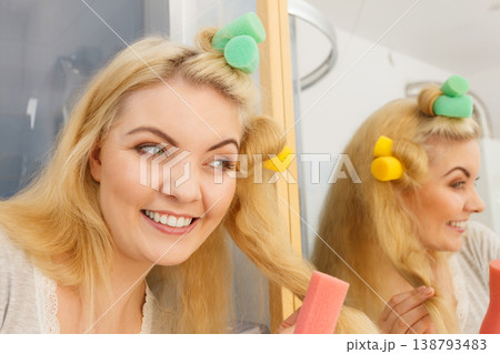 Blonde woman using hair rollers 138793483