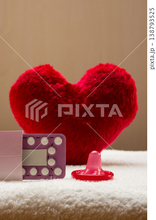 Oral contraceptive pills condom on red heart 138793525