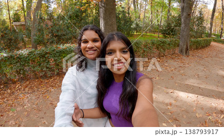 Indian women friends taking selfie in autumn park Indian women friends taking selfie in autumn park 138793917