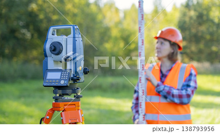 Worker wears high-visibility vest and orange helmet Worker wears high-visibility vest and orange helmet 138793956