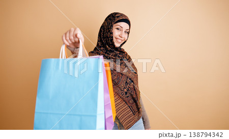 Muslim woman smiling holding colorful shopping bags 138794342