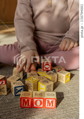 Baby stacking wooden blocks in a word mama. Concept of Mothers day. Baby stacking wooden blocks in a word mama. Concept of Mothers day. 138794881