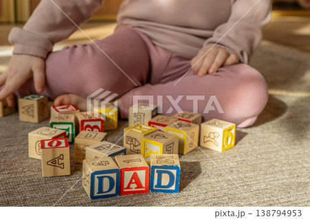 Baby stacking wooden blocks in a word dad. Concept of Fathers day.  138794953