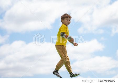 Young boy jumping high expressing freedom and joy Young boy jumping high expressing freedom and joy 138794985