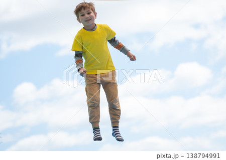 Boy floating playfully in blue sky enjoying freedom Boy floating playfully in blue sky enjoying freedom 138794991