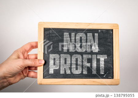 Non Profit Text on Chalkboard Held by Hand Representing Charity and Social Impact 138795055