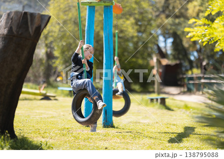 Happy young girl swinging on tire swing enjoying childhood 138795088