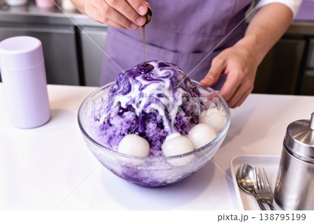 Traditional Japanese kakigori with purple syrup poured over shaved ice bowl 138795199
