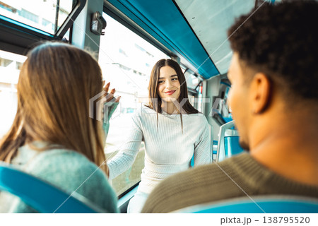 Young friends talking on public transport bus 138795520