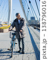 自転車を押して歩く60代男性 138796016