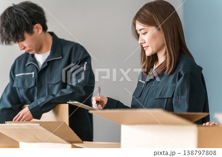 ダンボールに箱詰めする運送・物流・宅急便・宅配便・流通・配達・宅配業者の作業員の男女 138797808