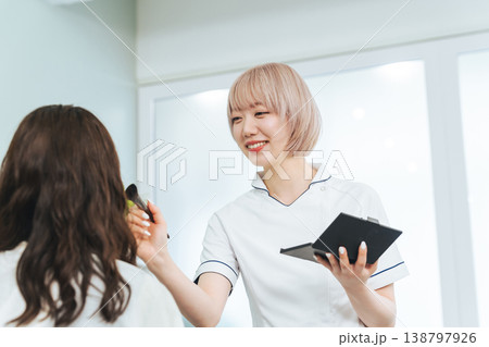 メイクするハイトーンヘアの女性スタッフ 138797926