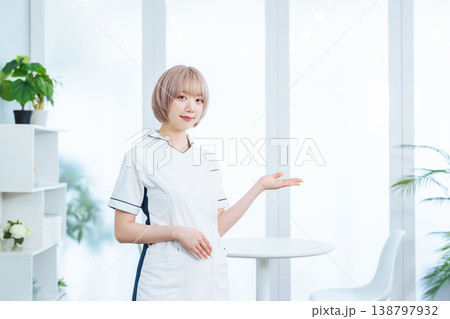 接客するハイトーンヘアの女性スタッフ 接客するハイトーンヘアの女性スタッフ 138797932