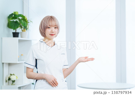 接客するハイトーンヘアの女性スタッフ 138797934