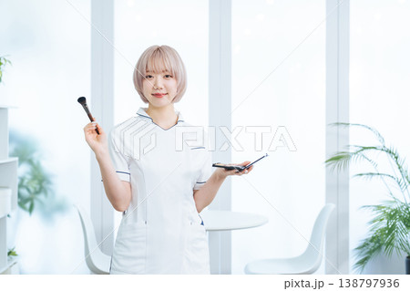 ヘアメイク道具を持つハイトーンヘアの女性スタッフ 138797936