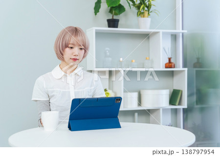 タブレットPCを見るハイトーンヘアの女性 138797954