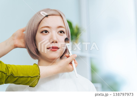 メイクしてもらうハイトーンヘアの女性 138797973