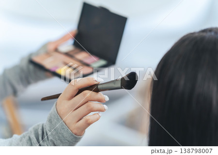 メイク道具を持ってメイクする女性スタッフ 138798007