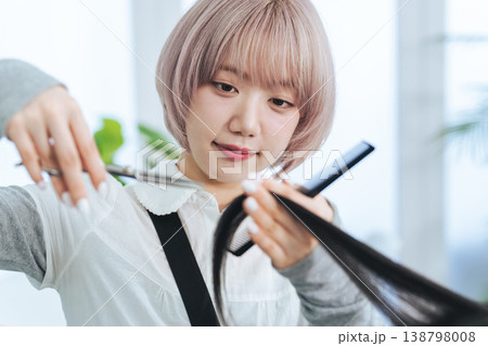 ヘアカットするハイトーンヘアの女性スタッフ ヘアカットするハイトーンヘアの女性スタッフ 138798008