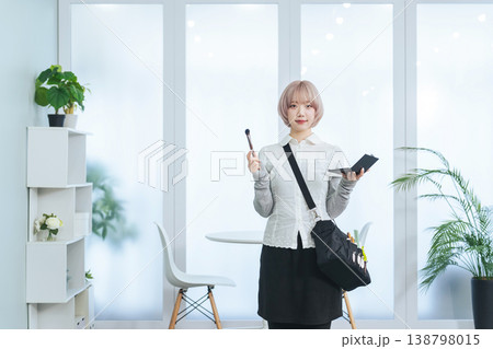 ヘアメイク道具を持つハイトーンヘアの女性スタッフ 138798015