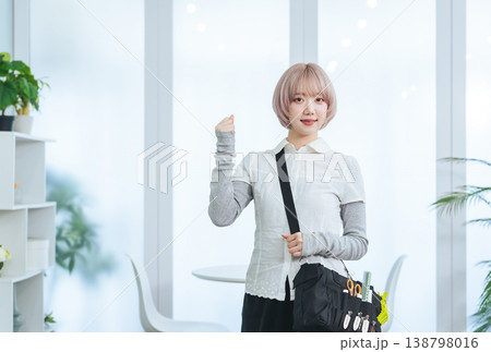 ヘアメイク道具を持つハイトーンヘアの女性スタッフ 138798016