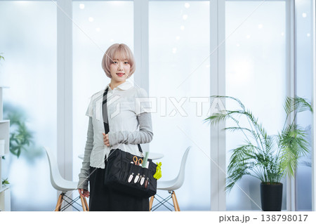 ヘアメイク道具を持つハイトーンヘアの女性スタッフ 138798017