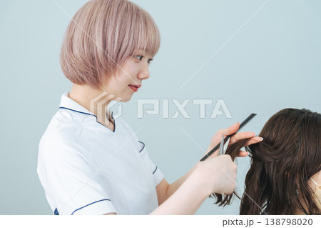 ヘアカットするハイトーンヘアの女性スタッフ ヘアカットするハイトーンヘアの女性スタッフ 138798020