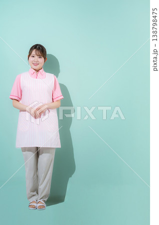 グリーン背景で介護士や保育士として働く女性の訪問介護とやりがいある仕事のイメージ　転職などのイメージ 138798475