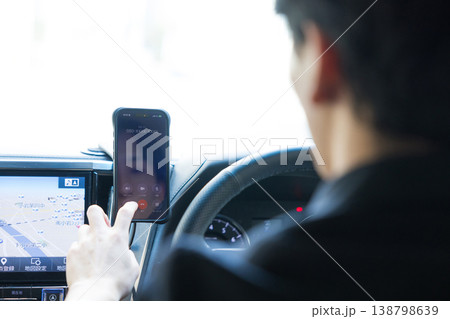 車を運転しながらスマホを操作するビジネスマン 138798639